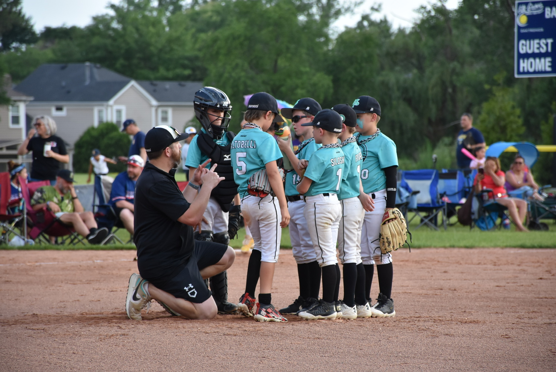 Mavs coach kneeling with players during a game