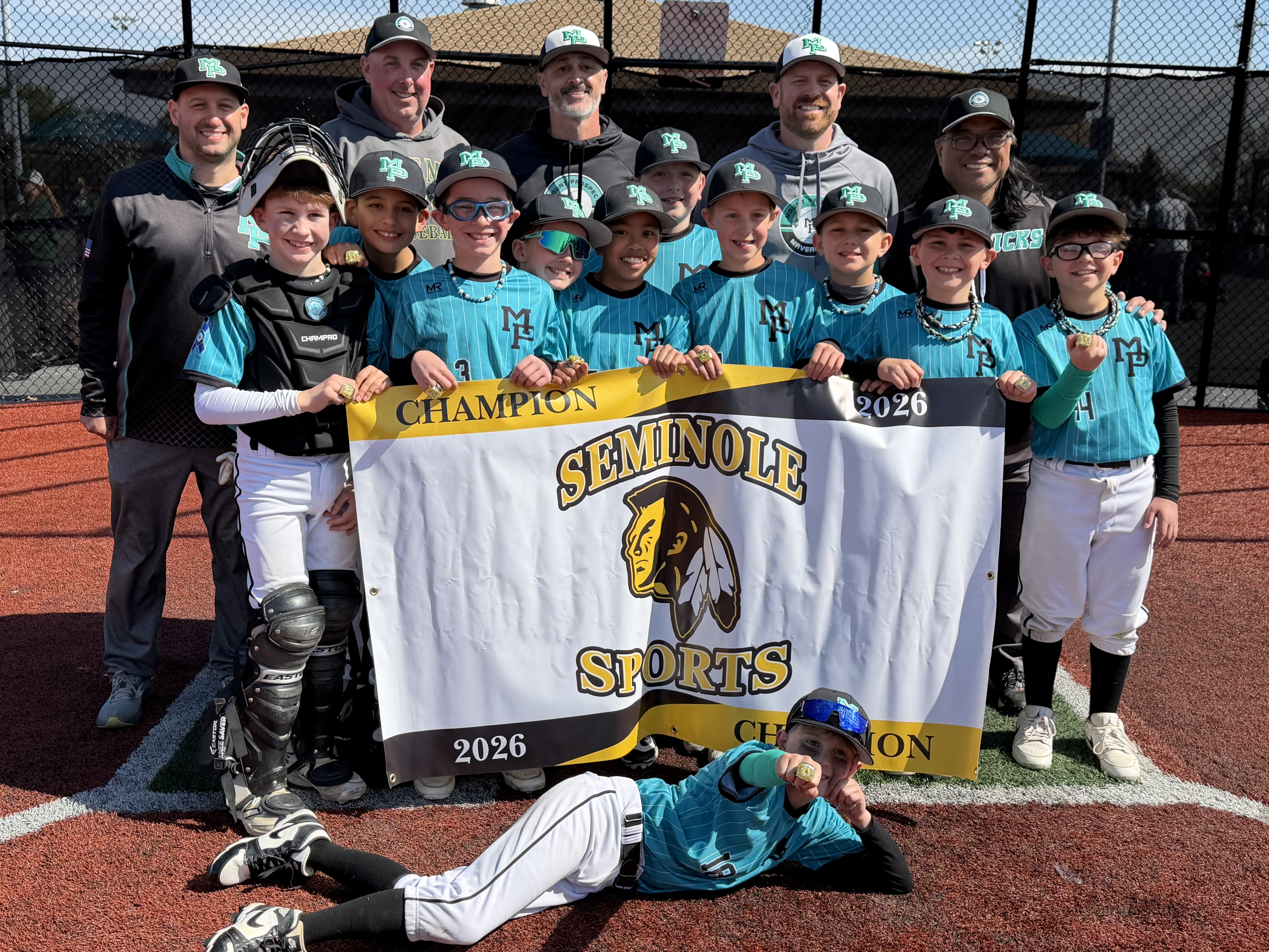 Mavericks holding Seminole Sports 2026 Champion banner